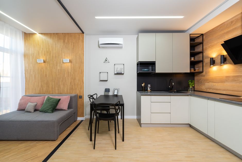Compacte woonkamer met hoekbank en slimme meubels.